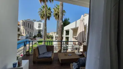 a balcony with a patio furniture and palm trees at Elizabeth Suites in Kato Daratso
