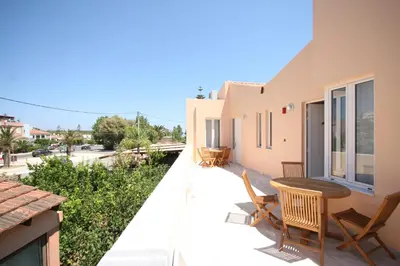 a balcony of a house with a table and chairs at Elma's Dream Apartments & Villas in Kato Daratso