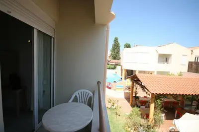 a balcony with a table and a view of a pool at Elma's Dream Apartments & Villas in Kato Daratso