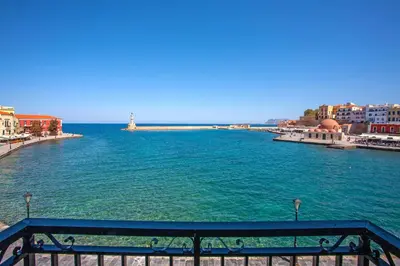 a view of a body of water with a lighthouse at Lucia Hotel in Chania Town