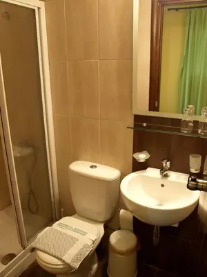 a bathroom with a white toilet and a sink at Hotel Filoxenia in Chania Town