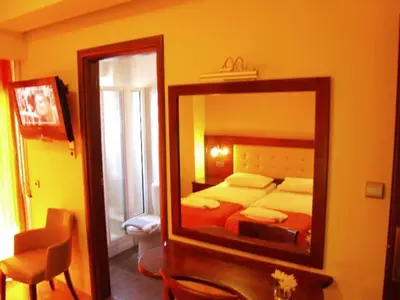 a mirror in a room with a bed and a bedroom at Hotel Filoxenia in Chania Town