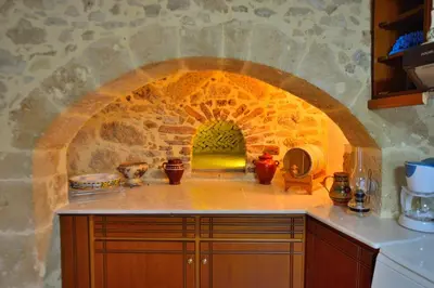 a kitchen with an archway in a stone wall at Archontiko Ilias in Kavoúsion