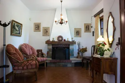 a living room with a fireplace and chairs at Alexandra Villa Stalos in Stalos