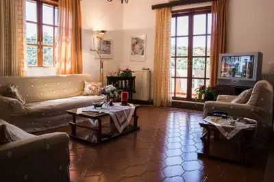 a living room with couches and tables and windows at Alexandra Villa Stalos in Stalos