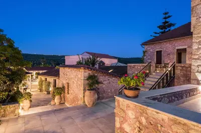 a house with a balcony with potted plants on it at Spilia Village Hotel & Villas in Spiliá