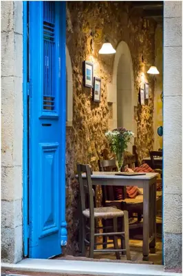 a blue door leading to a table and chairs at Nostos Hotel in Chania Town