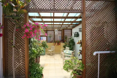 an open patio with flowers and a table and chairs at Nostos Hotel in Chania Town