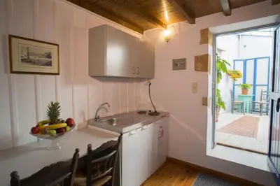 a kitchen with a sink and a bowl of fruit on the counter at Nostos Hotel in Chania Town