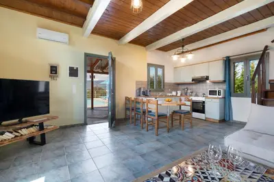 a kitchen and living room with a couch and a table at Villa Adriana in Arménoi