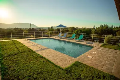 a swimming pool in a yard with two blue chairs at Villa Adriana in Arménoi