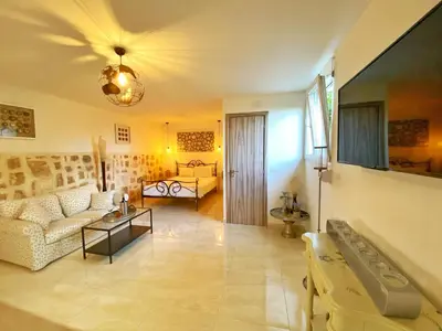 a living room with a couch and a table at MG Cozy Garden View Studio in Korakiaí