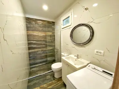 a bathroom with a toilet and a sink and a mirror at MG Cozy Garden View Studio in Korakiaí