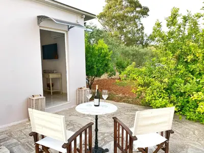 a patio with a table with wine glasses on it at MG Cozy Garden View Studio in Korakiaí