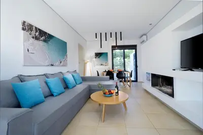 a living room with a gray couch and blue pillows at Seametry Villa in Chania Town