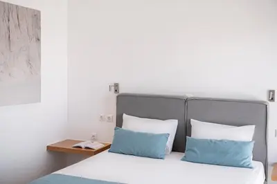 a bed with blue and white pillows in a room at Seametry Villa in Chania Town