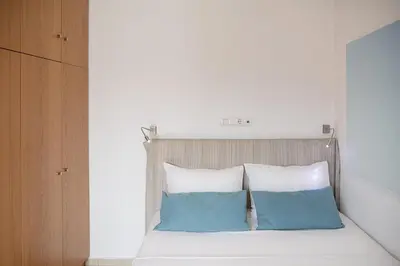 a bed with blue and white pillows on it at Seametry Villa in Chania Town