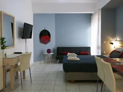 a bedroom with a bed and a table and a couch at Halepa Studios in Chania Town