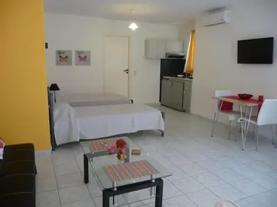 a room with a bed and a table and a kitchen at Halepa Studios in Chania Town
