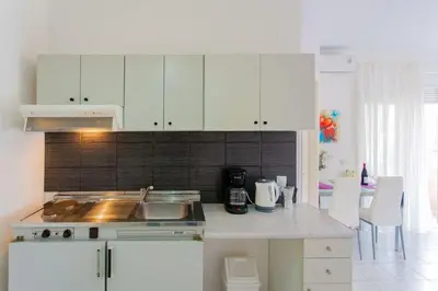 a kitchen with white cabinets and a counter top at Halepa Studios in Chania Town