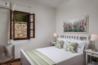 a white bedroom with a bed and a window at Koukounari luxury villa in Chania Town