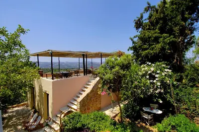 an outdoor patio with a canopy and tables and trees at Elia Hotel & Spa in Áno Voúvai
