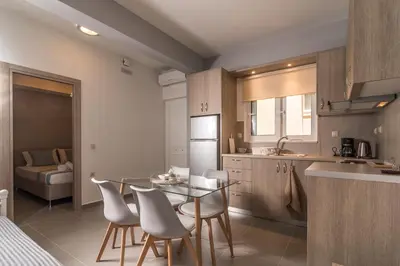 a kitchen with a table and chairs in a room at AnDi's Apartment's Paleochora in Palaiochóra