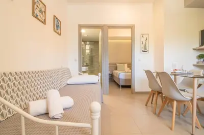 a living room with a couch and a dining room at AnDi's Apartment's Paleochora in Palaiochóra