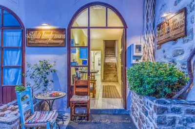 a blue building with a door and a table and chairs at Sofia's Lovely Rooms in Khóra Sfakíon