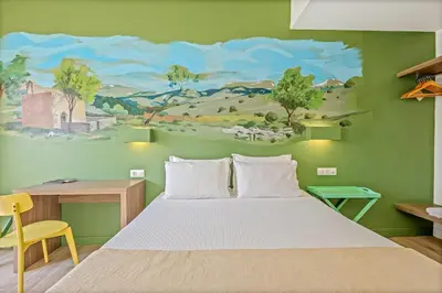 a bedroom with a bed and a painting on the wall at Sofia's Lovely Rooms in Khóra Sfakíon