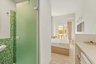 a bathroom with a shower and a bedroom at Sofia's Lovely Rooms in Khóra Sfakíon