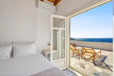 a bedroom with a bed and a view of the ocean at Sofia's Lovely Rooms in Khóra Sfakíon