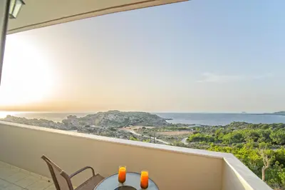 a balcony with a table and chairs and a view of the ocean at Panorama in Elafonisi