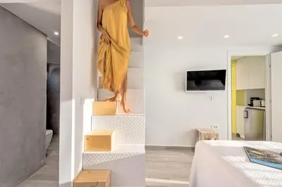 a woman in a yellow dress is walking down stairs at Aenaon Seaview Villa in Plataniás