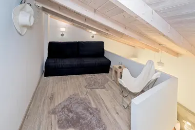 a living room with a black couch and a chair at Aenaon Seaview Villa in Plataniás