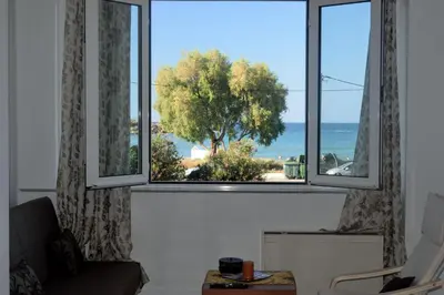 a living room with a window with a view of the ocean at Apartment next to the beach in Kato Daratso
