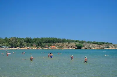 a group of people in the water at a beach at Apartment next to the beach in Kato Daratso