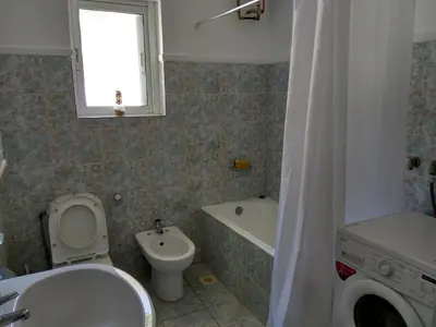 a bathroom with a toilet and a sink and a tub at Apartment next to the beach in Kato Daratso