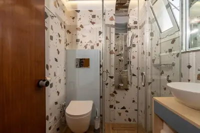 a bathroom with a shower with a toilet and a sink at Niki Rooms in Palaiochóra