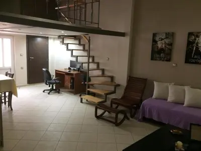 a living room with a spiral staircase and a desk at Maria's house in Kissamos