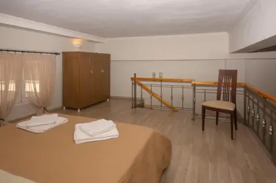 a room with a bed and a chair and a table at Maria's house in Kissamos