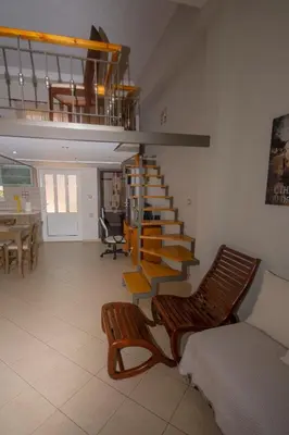 a living room with a staircase and a table and chairs at Maria's house in Kissamos