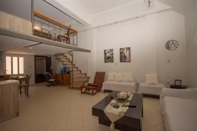 a living room with a couch and a stair case at Maria's house in Kissamos
