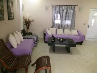a living room with purple couches and a table at Maria's house in Kissamos
