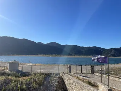 a boat on the water with a rainbow in the background at Mike Omalos Houses in Omalós