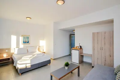 a bedroom with a bed and a living room at Casa Manolesos in Chorafakia