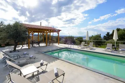 a swimming pool with chairs and a gazebo at Casa Manolesos in Chorafakia