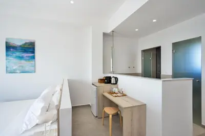 a kitchen with white walls and a table and chairs at Casa Manolesos in Chorafakia