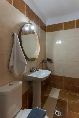 a bathroom with a sink and a mirror and a toilet at Margiani House in Kaláthenai