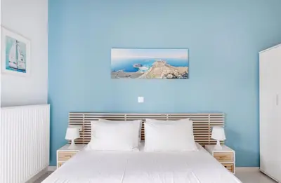 a bedroom with blue walls and a bed with white pillows at Villa Despina in Kisamos in Kissamos